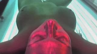 Брюнетка наслаждается солярием