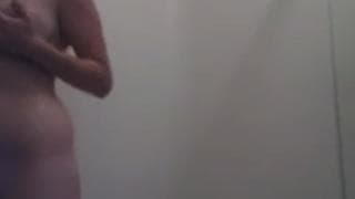 Брюнетка намыливает свое тело в душе