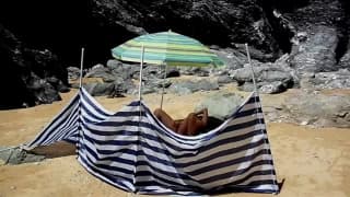 Она лежит голая и мастурбирует на пляже